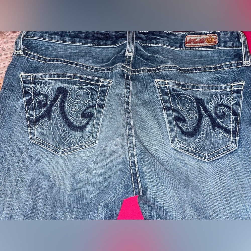 LIGHT BLUE FLARED JEANS. DETAILS ON BACK POCKETS